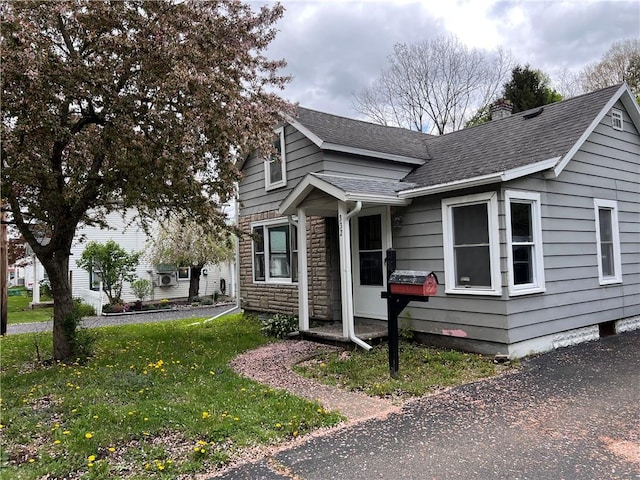 332 Jamestown St, Persia, NY 14070 - view of front of house featuring roof with shingles, stone siding, a front lawn, and a chimney