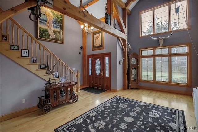 100 May Dr, Elma, NY 14059 - foyer entrance featuring wood finished floors, a high ceiling, a chandelier, stairway, and baseboards