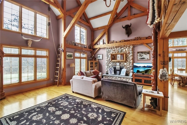 100 May Dr, Elma, NY 14059 - living area featuring high vaulted ceiling, wood finished floors, a stone fireplace, and beam ceiling