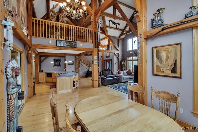 100 May Dr, Elma, NY 14059 - dining area featuring high vaulted ceiling, a chandelier, stairway, and light wood-type flooring