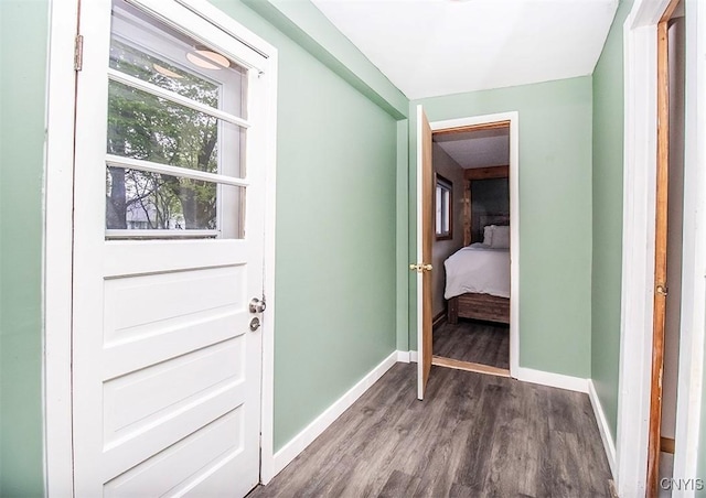 doorway to outside featuring wood finished floors and baseboards