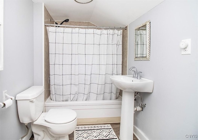 full bathroom featuring vaulted ceiling, toilet, shower / bath combination with curtain, and wood finished floors