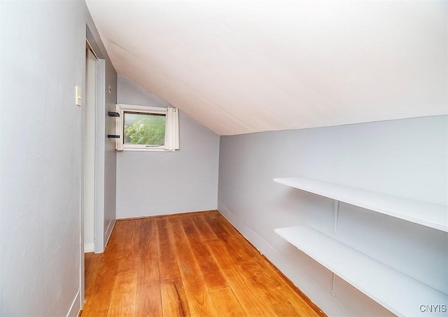 bonus room featuring vaulted ceiling and light wood-style flooring