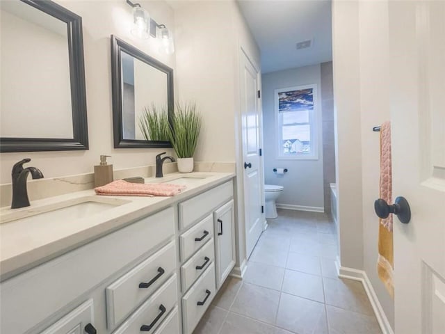1549 Osburn Ln, Farmington, NY 14425 - bathroom with toilet, double vanity, tile patterned floors, baseboards, and a bathtub