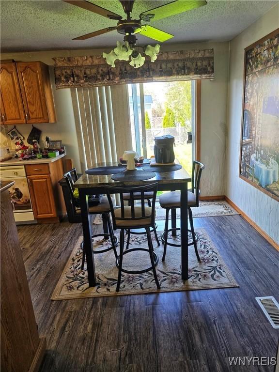 6943 Academy Ln, Lockport-Town, NY 14094 - dining area featuring dark wood-type flooring, ceiling fan, a textured ceiling, and baseboards