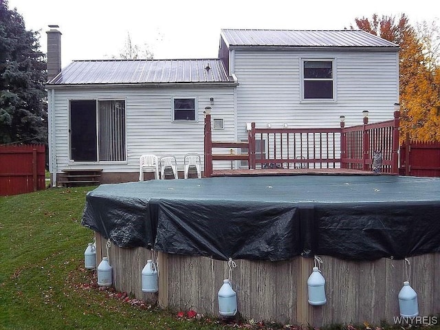 6943 Academy Ln, Lockport-Town, NY 14094 - rear view of property featuring a wooden deck, a chimney, metal roof, and a covered pool