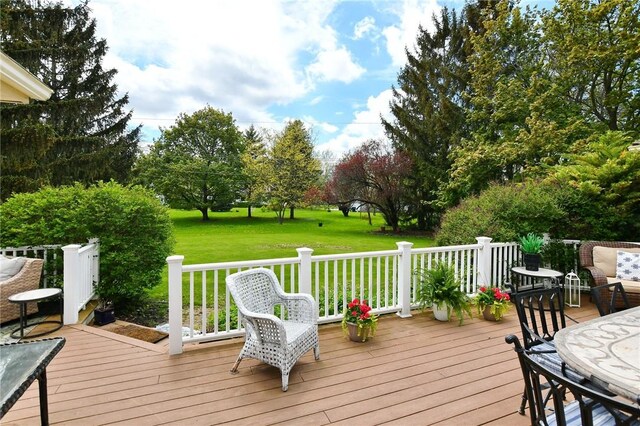 wooden deck featuring a lawn