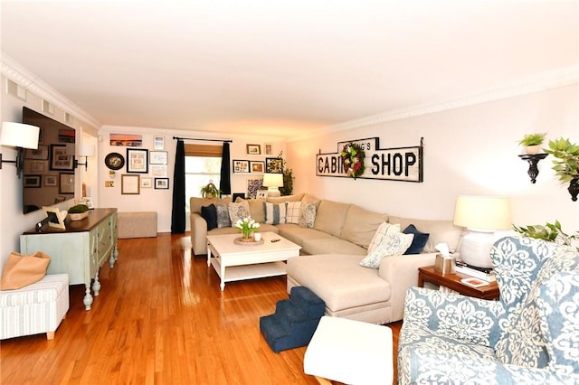 living area featuring light wood-style flooring and ornamental molding