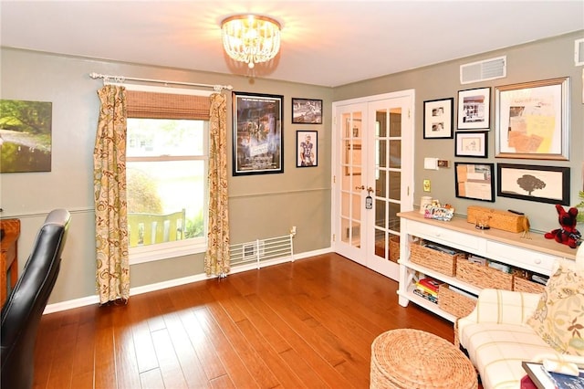 living area with french doors, baseboards, wood-type flooring, and a chandelier