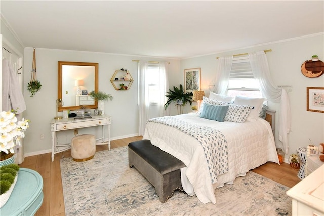 bedroom featuring ornamental molding, wood finished floors, and baseboards
