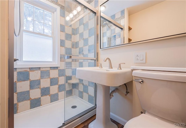 bathroom featuring toilet, a shower stall, and plenty of natural light