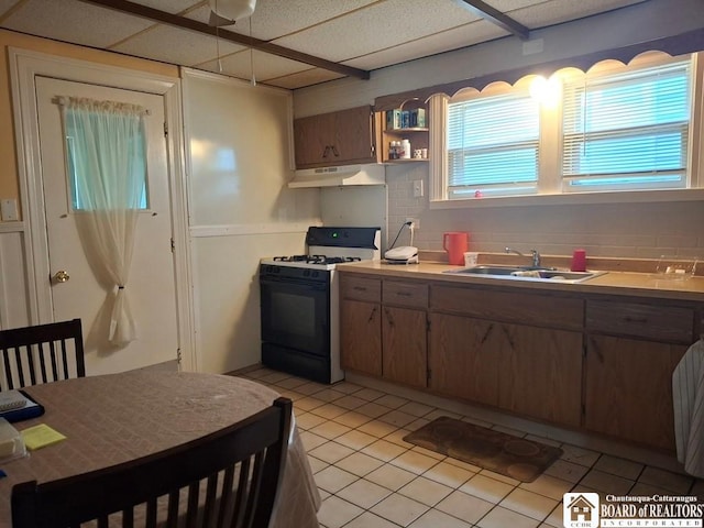 11 Prather Ave, Jamestown, NY 14701 - kitchen with gas range, a sink, under cabinet range hood, light tile patterned floors, and light countertops