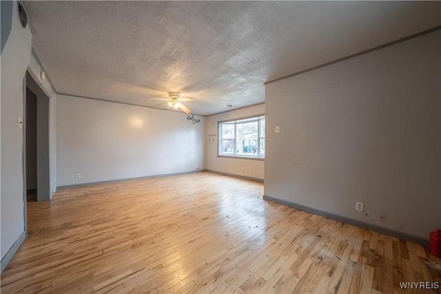 unfurnished room featuring ceiling fan, light wood-style flooring, a textured ceiling, and baseboards