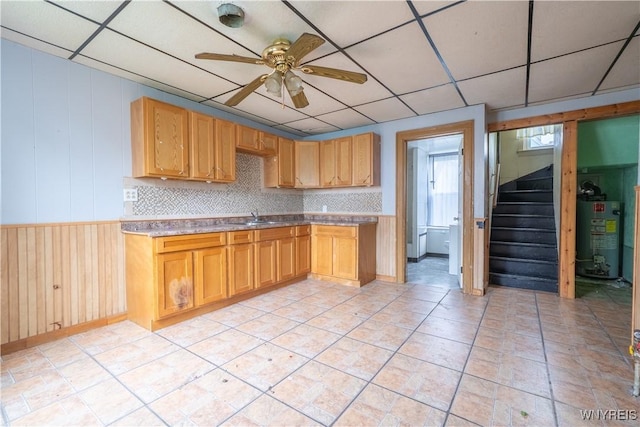 kitchen featuring electric water heater, ceiling fan, a sink, a paneled ceiling, and light countertops