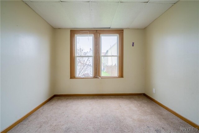 carpeted spare room featuring baseboards