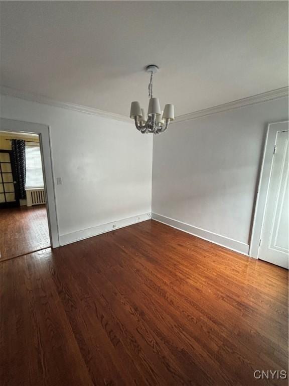 unfurnished dining area featuring ornamental molding, a chandelier, dark wood-type flooring, baseboards, and radiator heating unit
