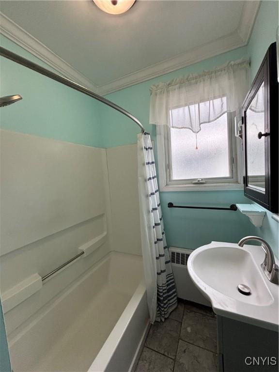 bathroom with crown molding, shower / bath combination with curtain, and vanity
