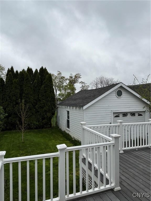 wooden deck featuring an outdoor structure and a lawn