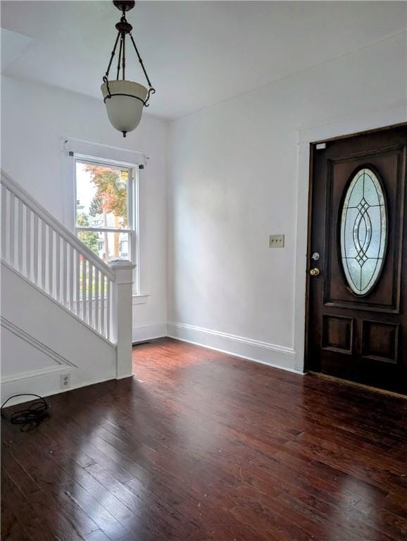 foyer entrance with wood-type flooring, stairs, and baseboards