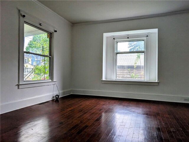 unfurnished room featuring plenty of natural light, dark wood-style floors, baseboards, and ornamental molding