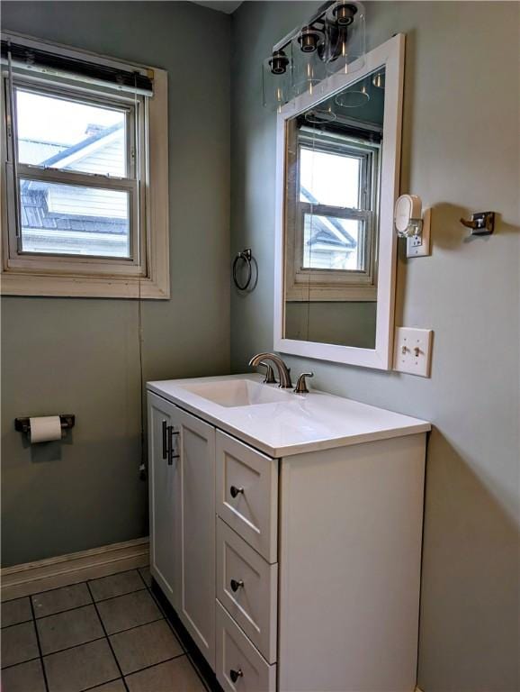 bathroom with plenty of natural light, tile patterned flooring, baseboards, and vanity