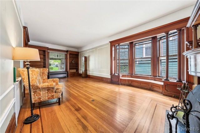 82 Clinton St, Tonawanda-City, NY 14150 - sitting room featuring a decorative wall, wood-type flooring, and baseboard heating