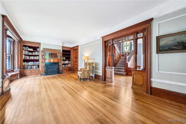 82 Clinton St, Tonawanda-City, NY 14150 - living room featuring a fireplace, light wood-style flooring, baseboards, stairway, and built in features