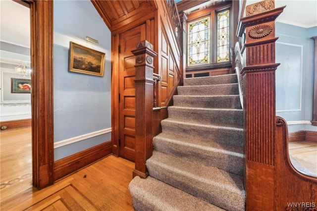 82 Clinton St, Tonawanda-City, NY 14150 - stairway featuring wood finished floors, baseboards, crown molding, and a chandelier