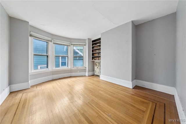 82 Clinton St, Tonawanda-City, NY 14150 - empty room featuring baseboards, light wood-type flooring, and built in shelves