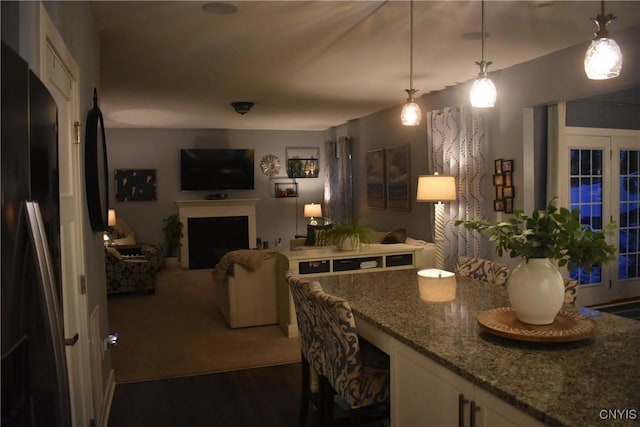 5546 Rolling Meadows Way, Camillus, NY 13031 - kitchen with stone countertops, white cabinets, pendant lighting, a fireplace, and dark wood-style floors