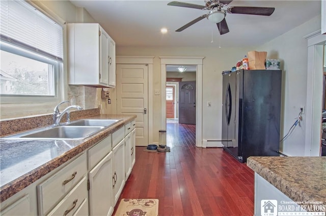 kitchen with freestanding refrigerator, a sink, plenty of natural light, white cabinetry, and recessed lighting
