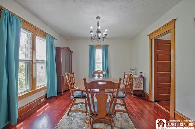 dining room featuring a chandelier, hardwood / wood-style flooring, a textured ceiling, and healthy amount of natural light