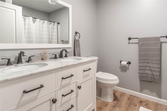 29556 County Route 46, Le Ray, NY 13637 - full bathroom with toilet, double vanity, wood finished floors, and baseboards