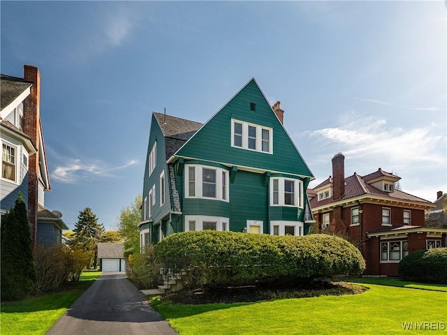 47 Beard Ave, Buffalo, NY 14214 - victorian home featuring a front yard, a chimney, and a garage
