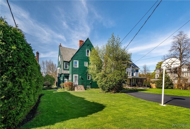 47 Beard Ave, Buffalo, NY 14214 - back of house with a chimney, a yard, and a shingled roof