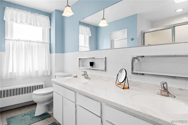 47 Beard Ave, Buffalo, NY 14214 - full bath featuring radiator heating unit, toilet, an enclosed shower, double vanity, and tile walls