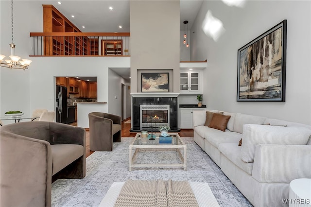 20 Harbour Pointe, Buffalo, NY 14202 - living room with a chandelier, a high ceiling, a tiled fireplace, recessed lighting, and light wood-type flooring