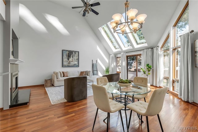 20 Harbour Pointe, Buffalo, NY 14202 - dining space featuring high vaulted ceiling, a chandelier, a fireplace, a skylight, and a ceiling fan