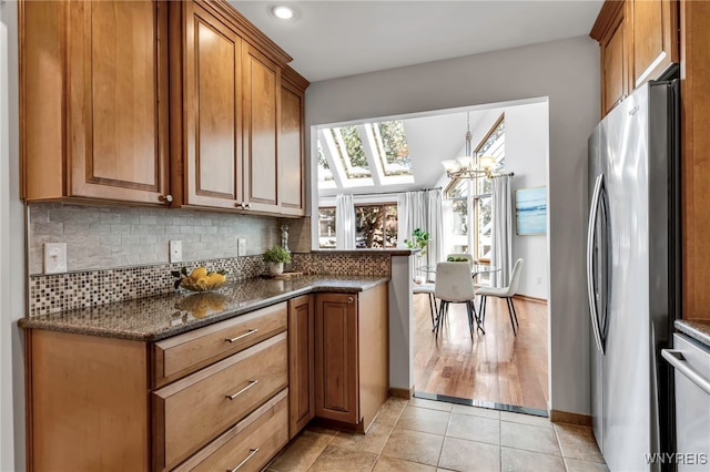 20 Harbour Pointe, Buffalo, NY 14202 - kitchen with freestanding refrigerator, brown cabinets, a skylight, backsplash, and recessed lighting