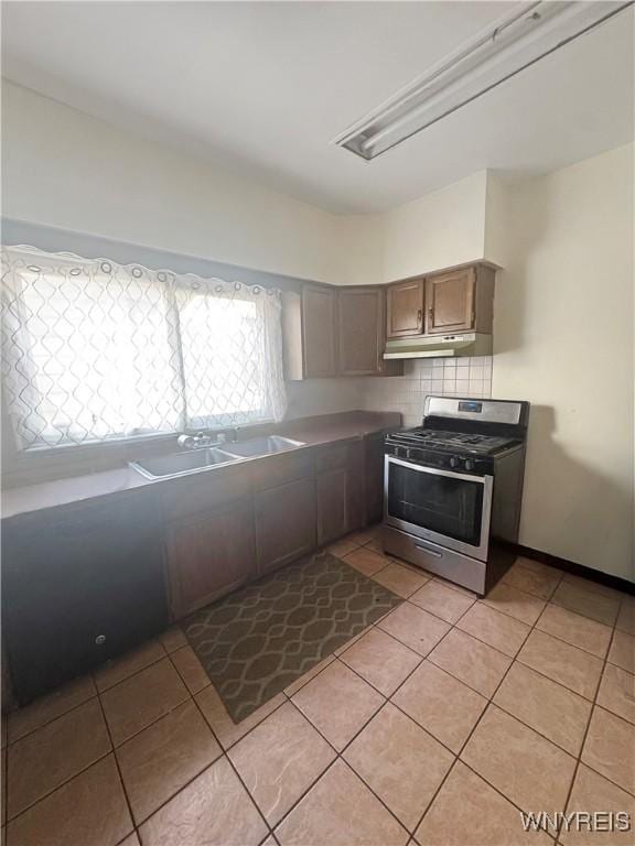75 Northrup Pl, Buffalo, NY 14214 - kitchen with stainless steel range with gas cooktop, light tile patterned floors, under cabinet range hood, and a sink