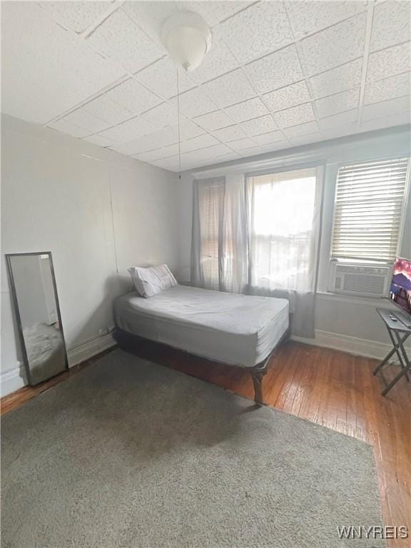 75 Northrup Pl, Buffalo, NY 14214 - bedroom with wood-type flooring, cooling unit, a paneled ceiling, and baseboards