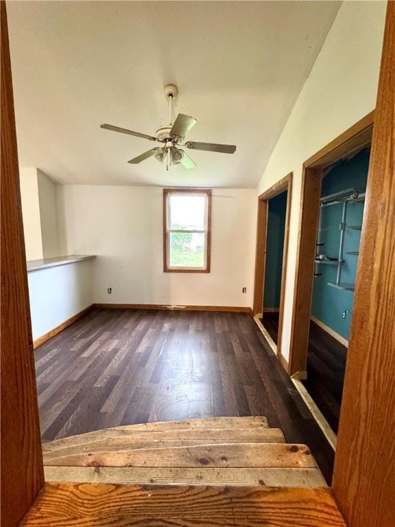 unfurnished room featuring wood finished floors, lofted ceiling, baseboards, and a ceiling fan