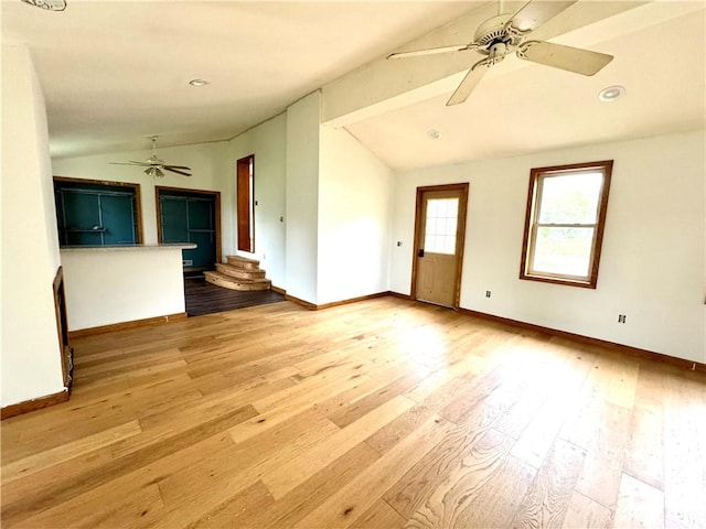 unfurnished living room featuring vaulted ceiling, ceiling fan, hardwood / wood-style floors, and baseboards