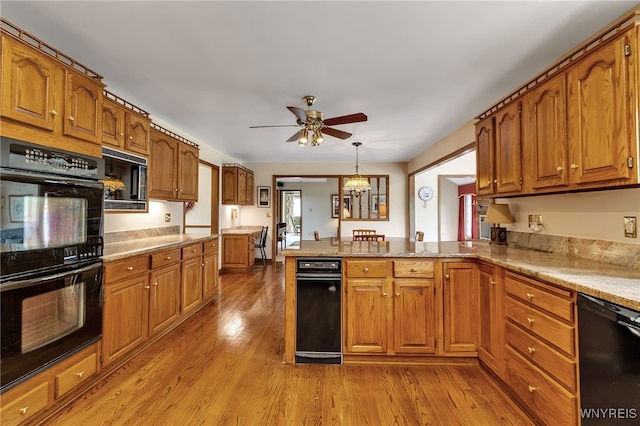 kitchen featuring black appliances, brown cabinetry, ceiling fan, and a peninsula