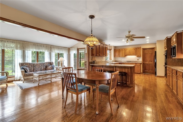 dining room with wood finished floors, vaulted ceiling, ceiling fan, and recessed lighting