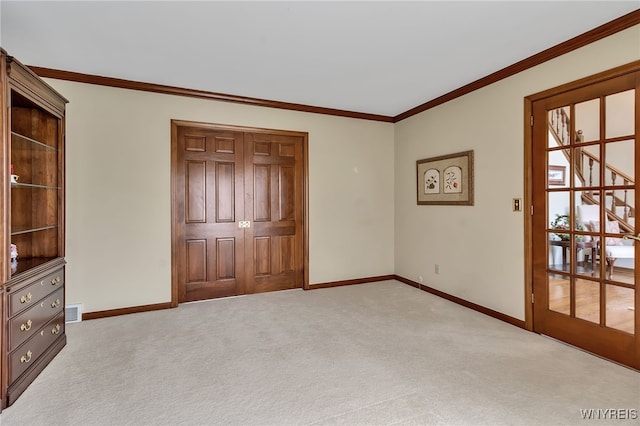 unfurnished bedroom featuring baseboards, carpet flooring, and crown molding