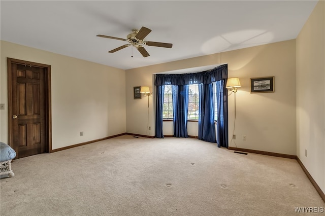 empty room with a ceiling fan, carpet flooring, and baseboards