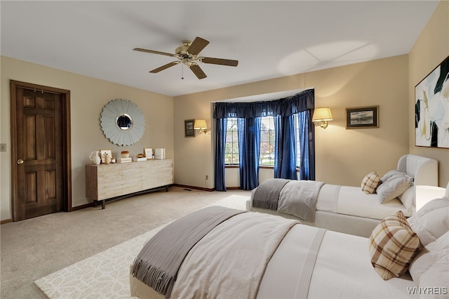 bedroom featuring light colored carpet, baseboards, and ceiling fan