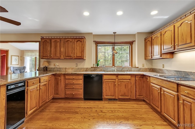 kitchen featuring black appliances, a sink, healthy amount of natural light, brown cabinets, and recessed lighting