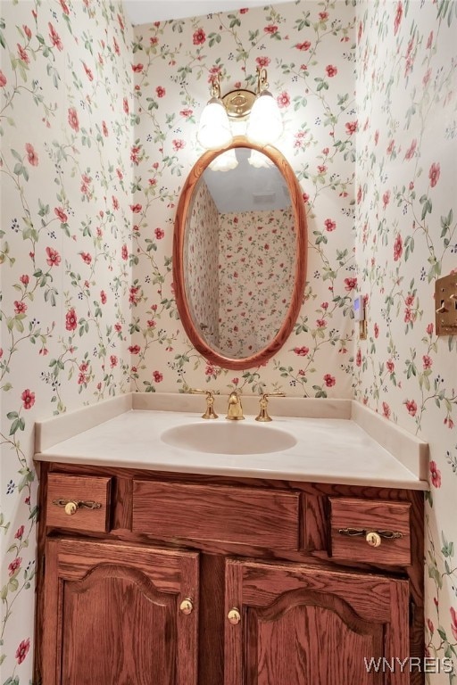 bathroom with wallpapered walls and vanity
